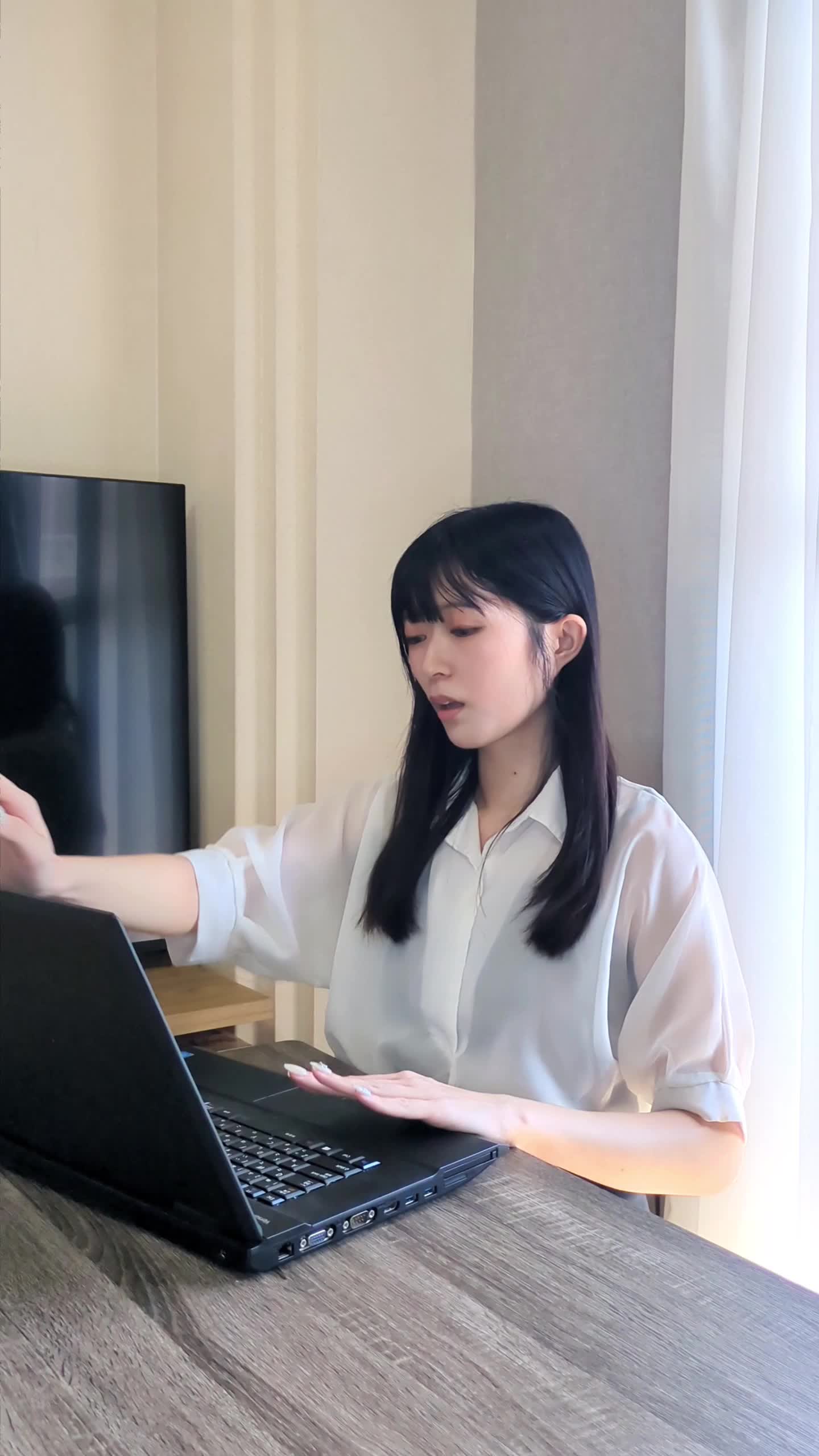 パソコンを閉じて軽く伸びをし、リフレッシュする仕草