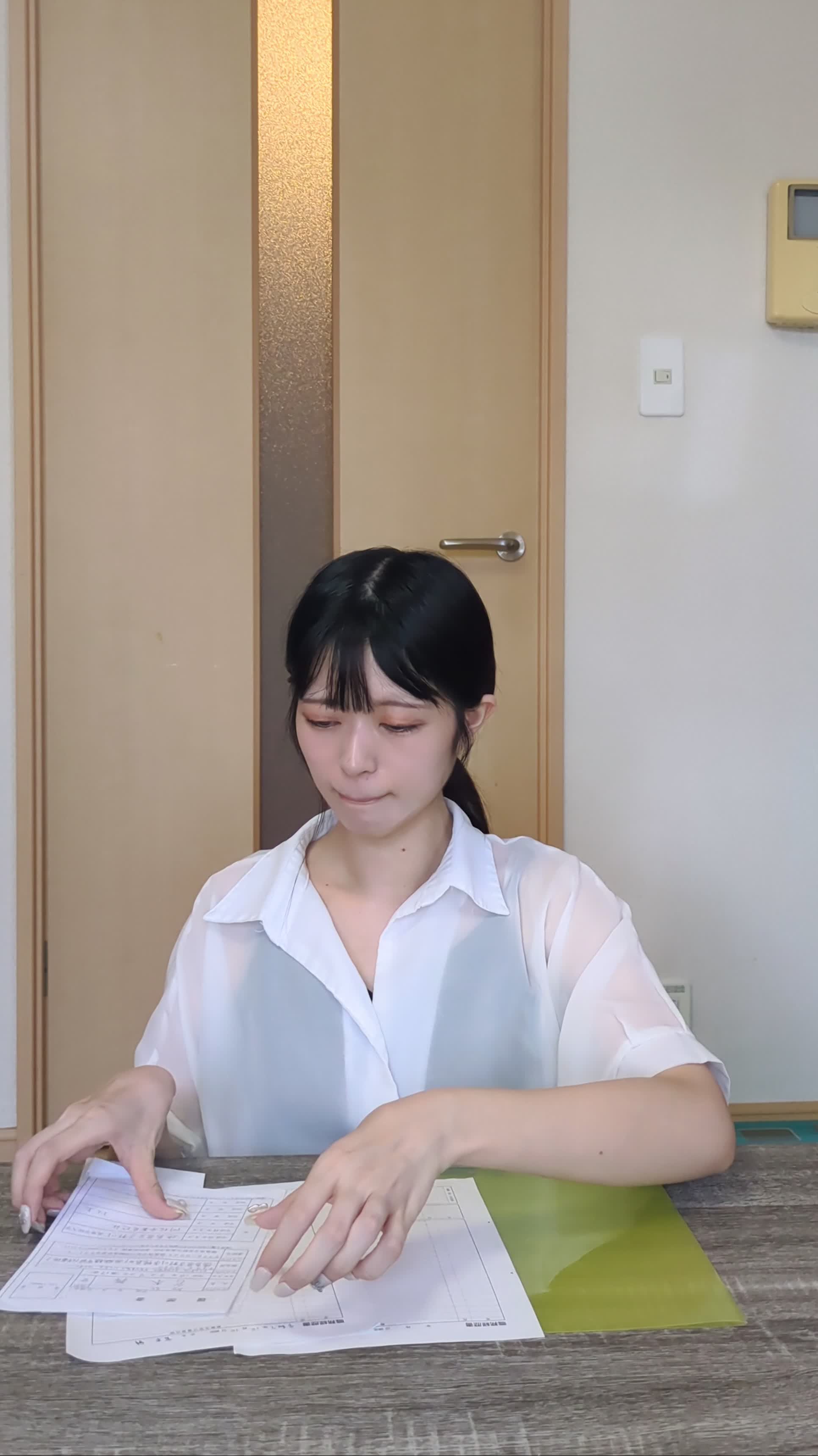 ダイニングテーブルで応募書類を整理している