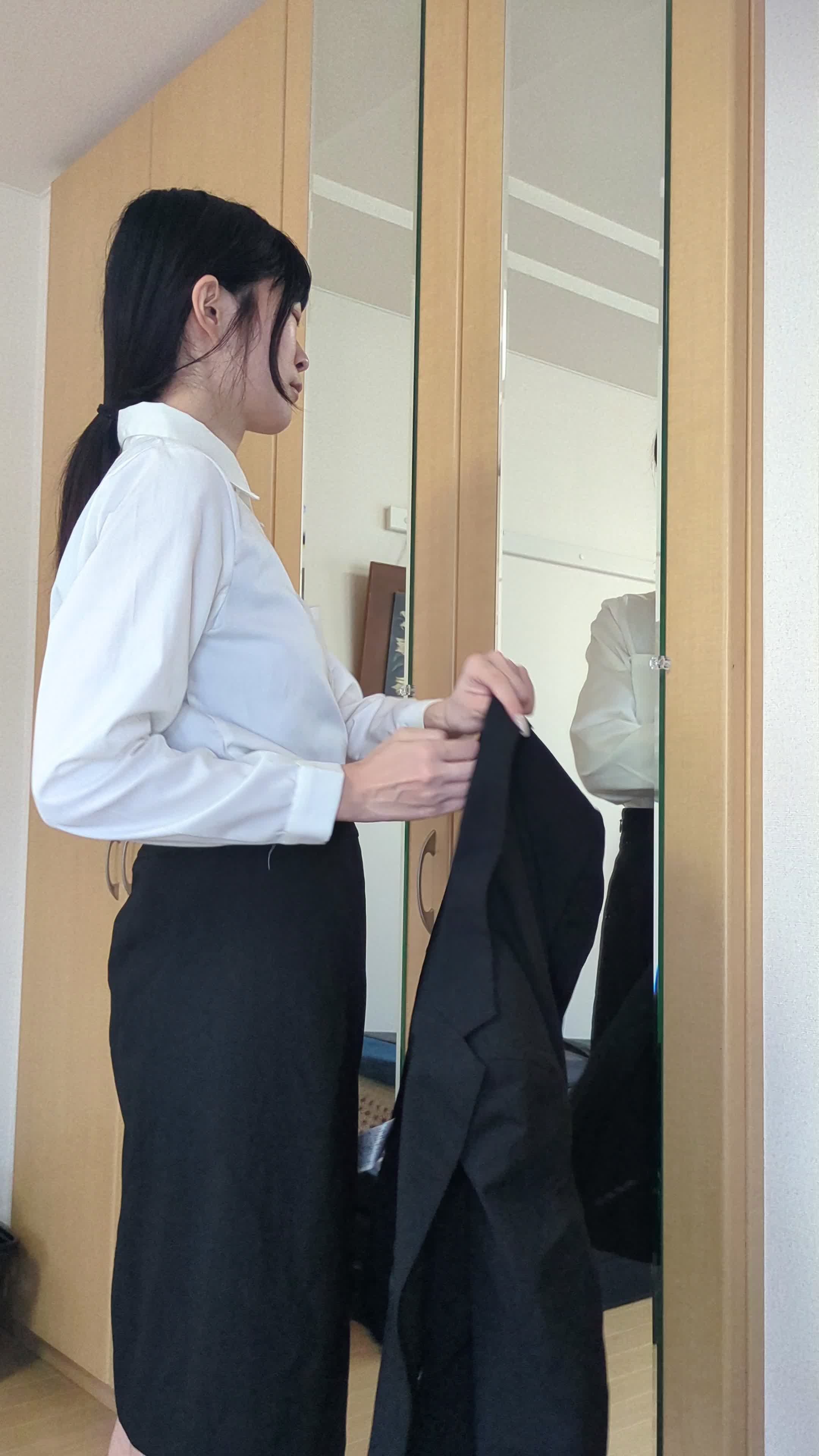 鏡の前でジャケットを着る練習をしている