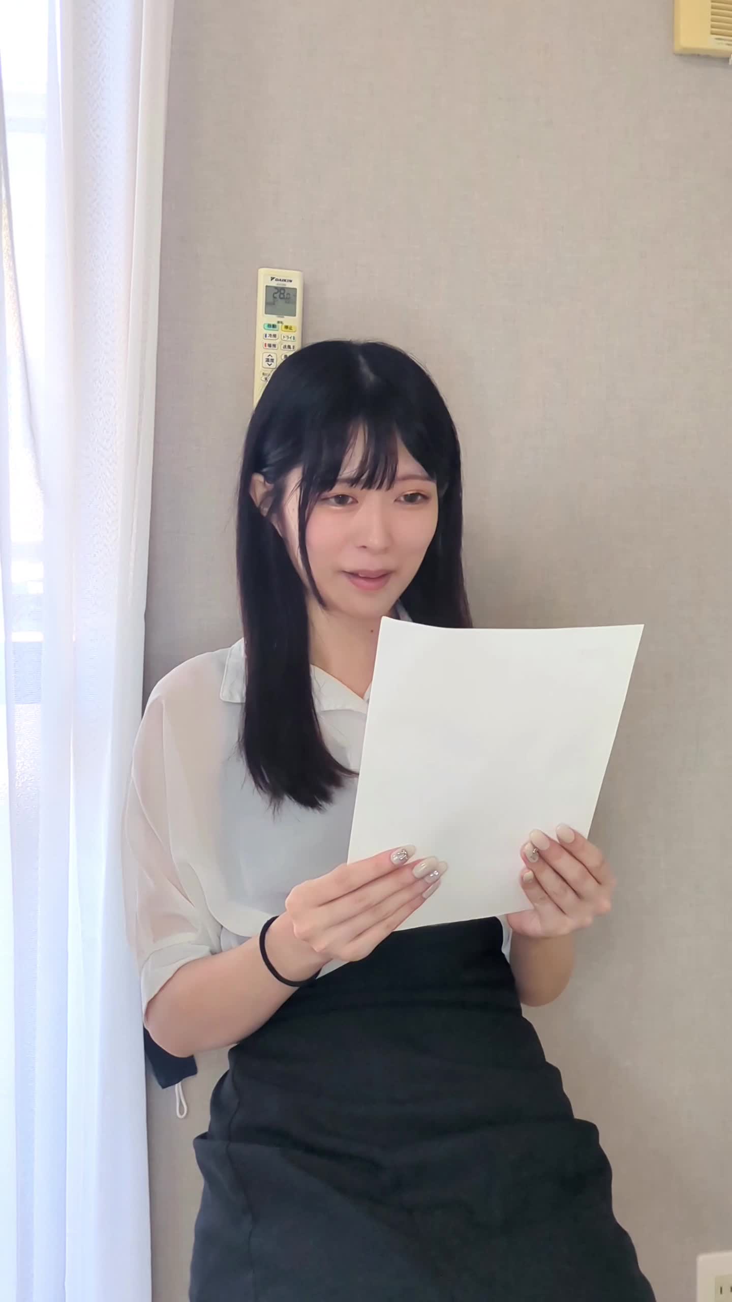 椅子に深く腰掛け、軽く微笑みながら内定通知を読んでいる