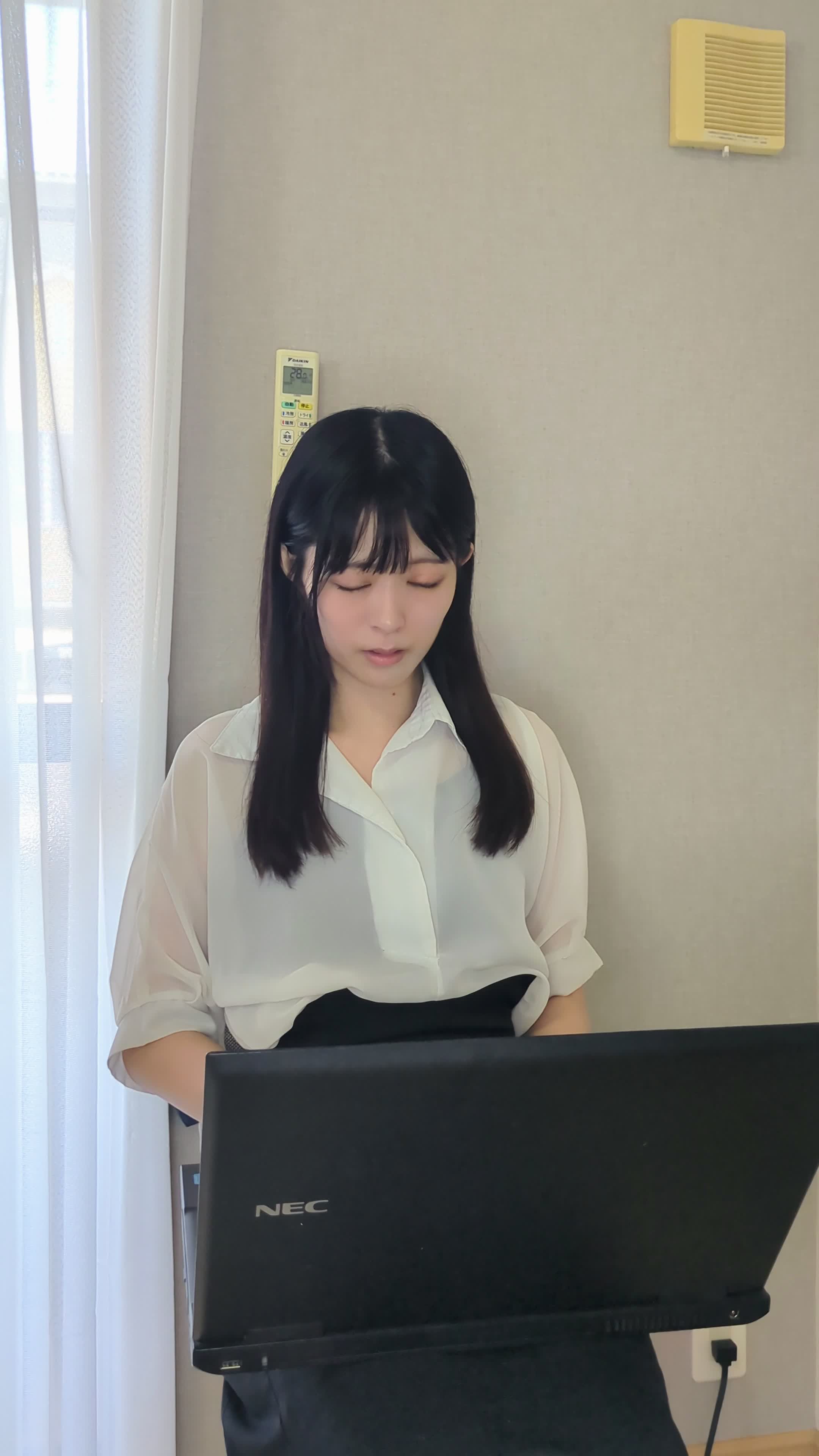 椅子に座り、パソコンで履歴書を更新している様子