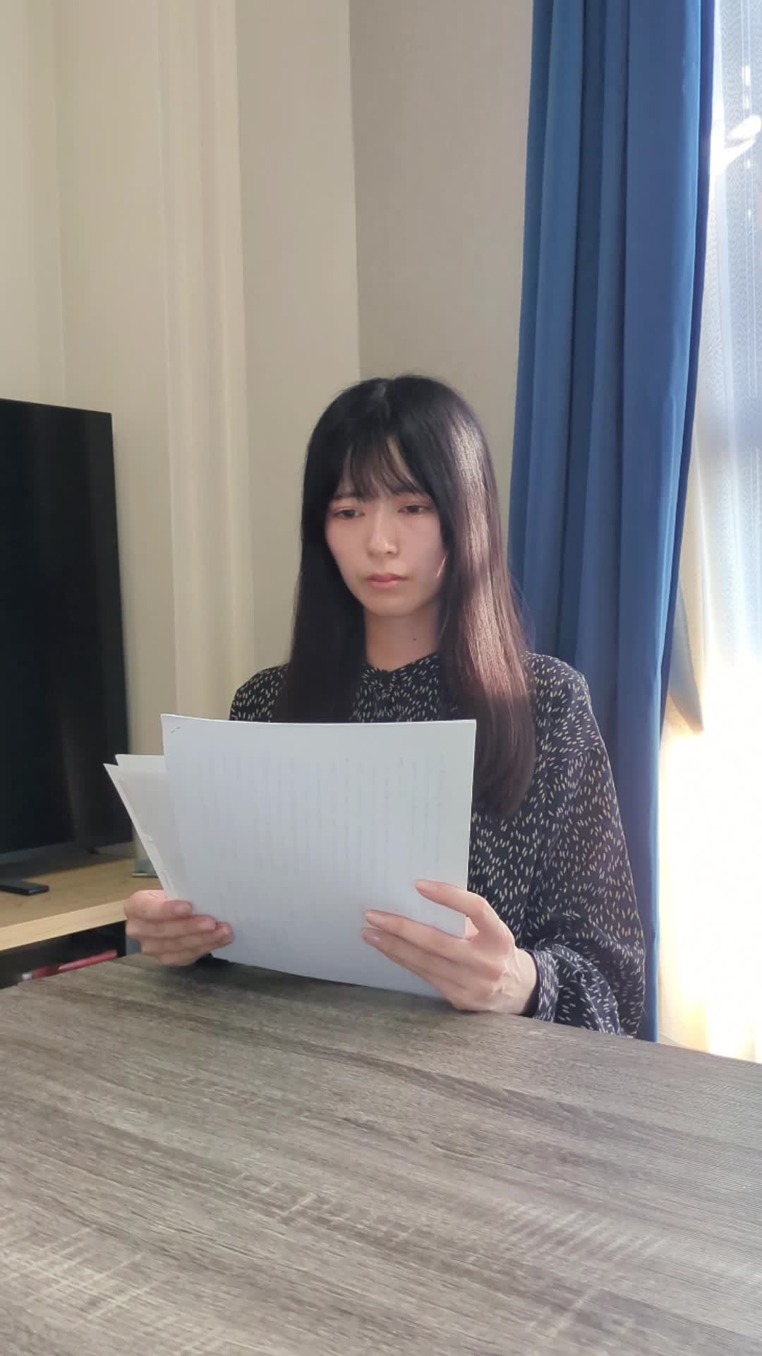 テーブルで車の査定書を手に取り、真剣に見つめている様子