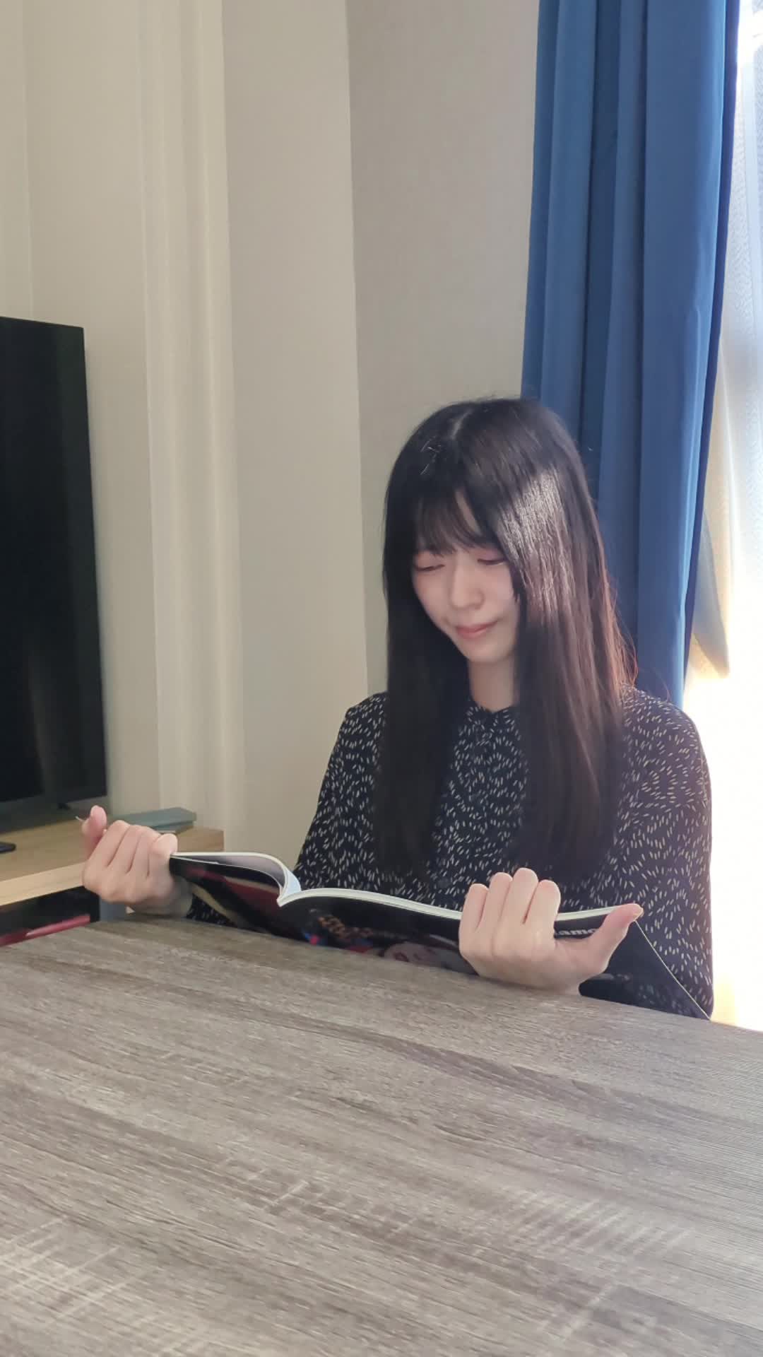 テーブルでカタログを広げ、「これを売ったら次はこの車かな」と考える仕草