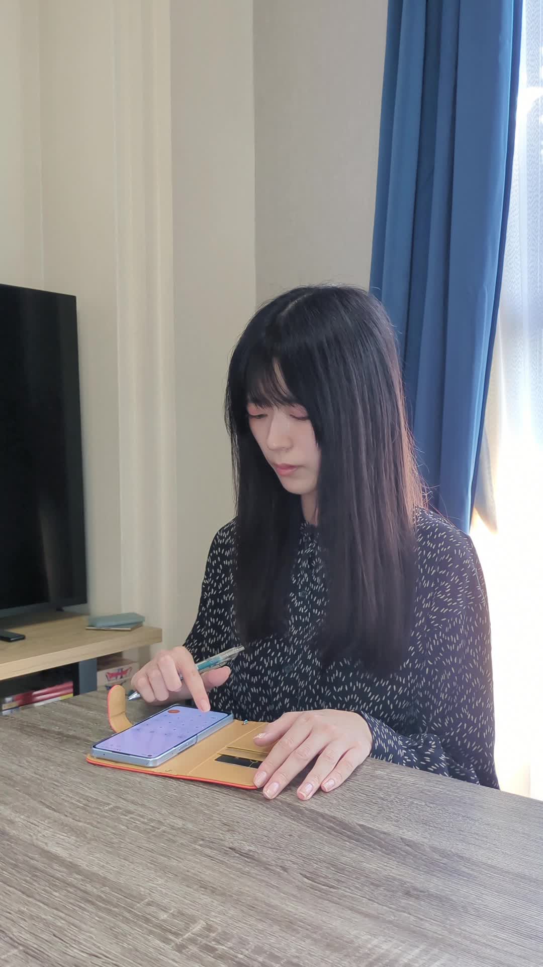 テーブルで電卓を叩きながら、「この金額なら次のローンもいけるかも」と計算する様子