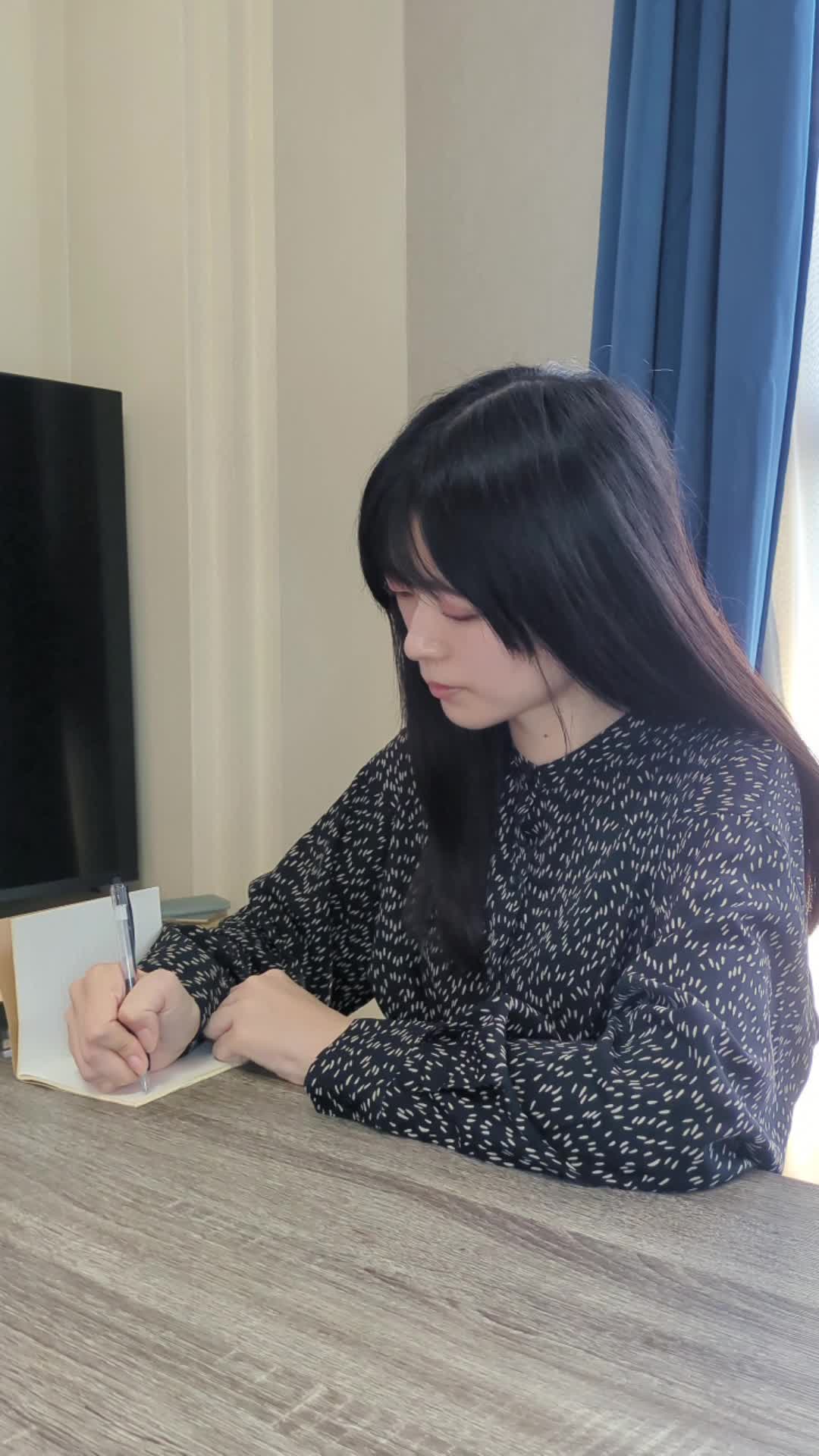 テーブルでメモ帳にチェックリストを書きながらチェックする動作