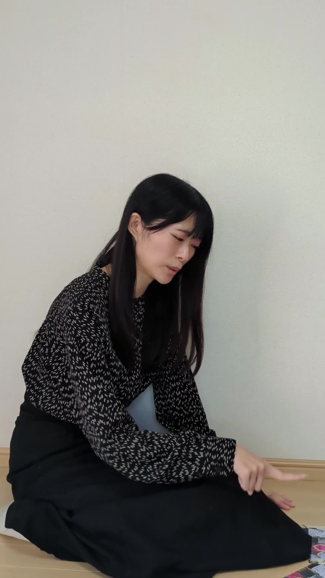 床に座り、車の写真を並べて「どれが高く売れるかな」と悩む様子