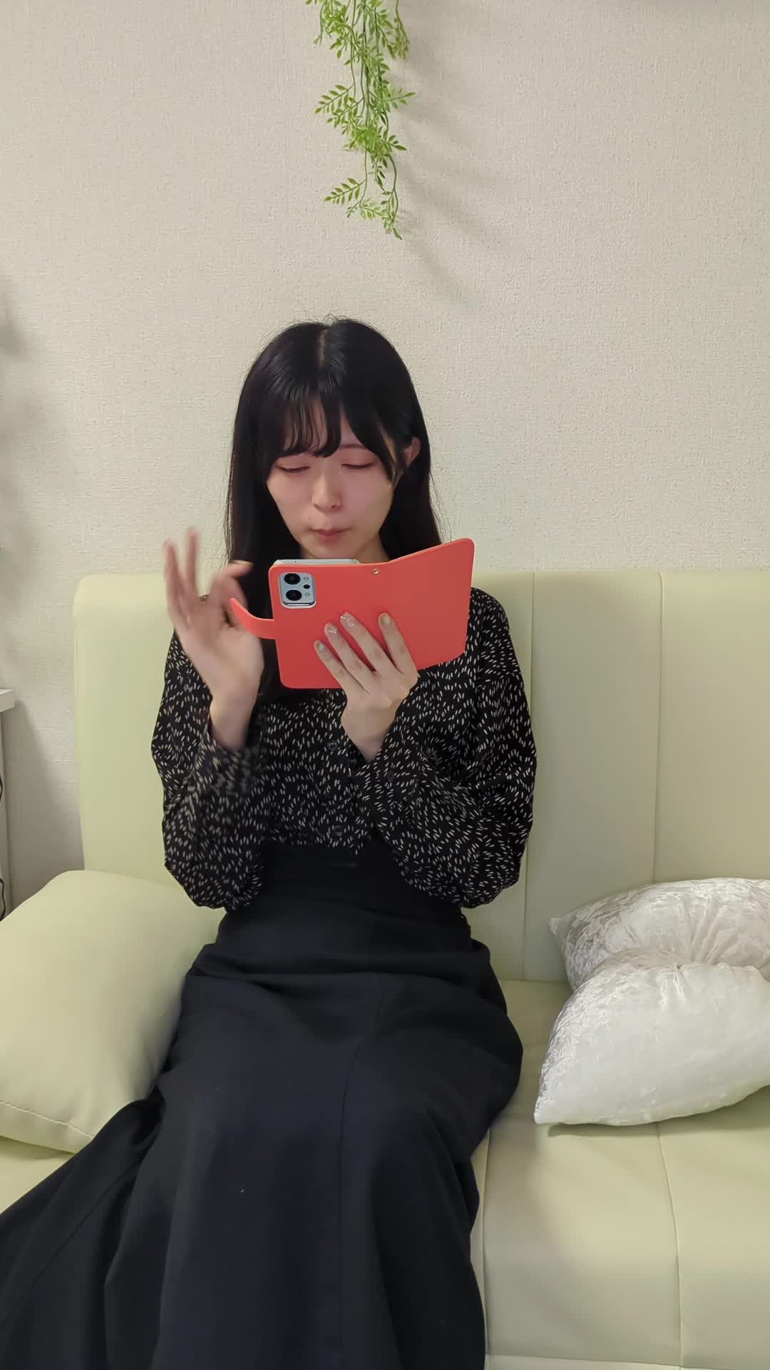 椅子に腰掛け、スマホで査定フォームを入力しながら期待する顔
