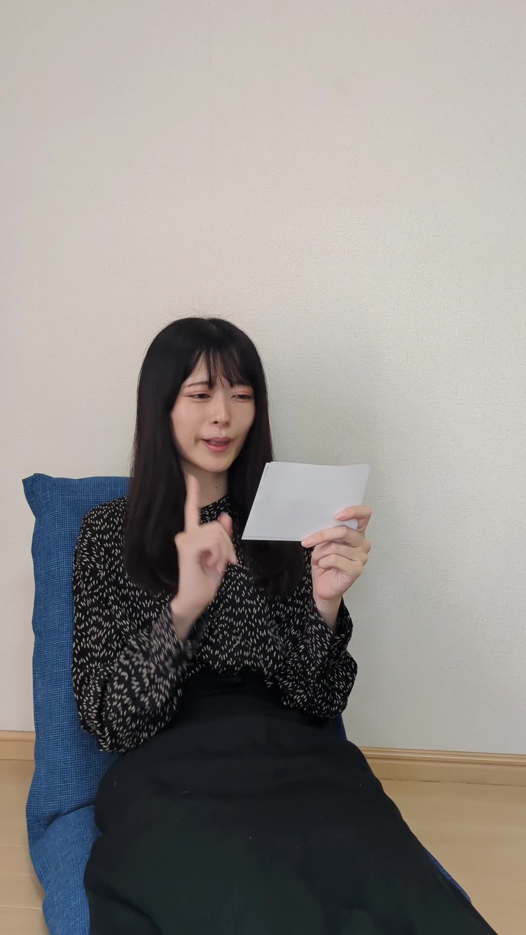 椅子に座り、車の写真を見ながら「これなら売れるかも！」と自信を持つ表情