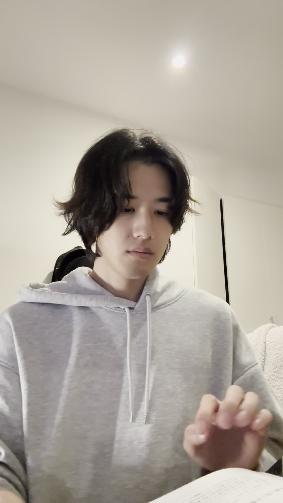 椅子に座り、テーブルに広げた資料を指でなぞりながら真剣に考え込む表情