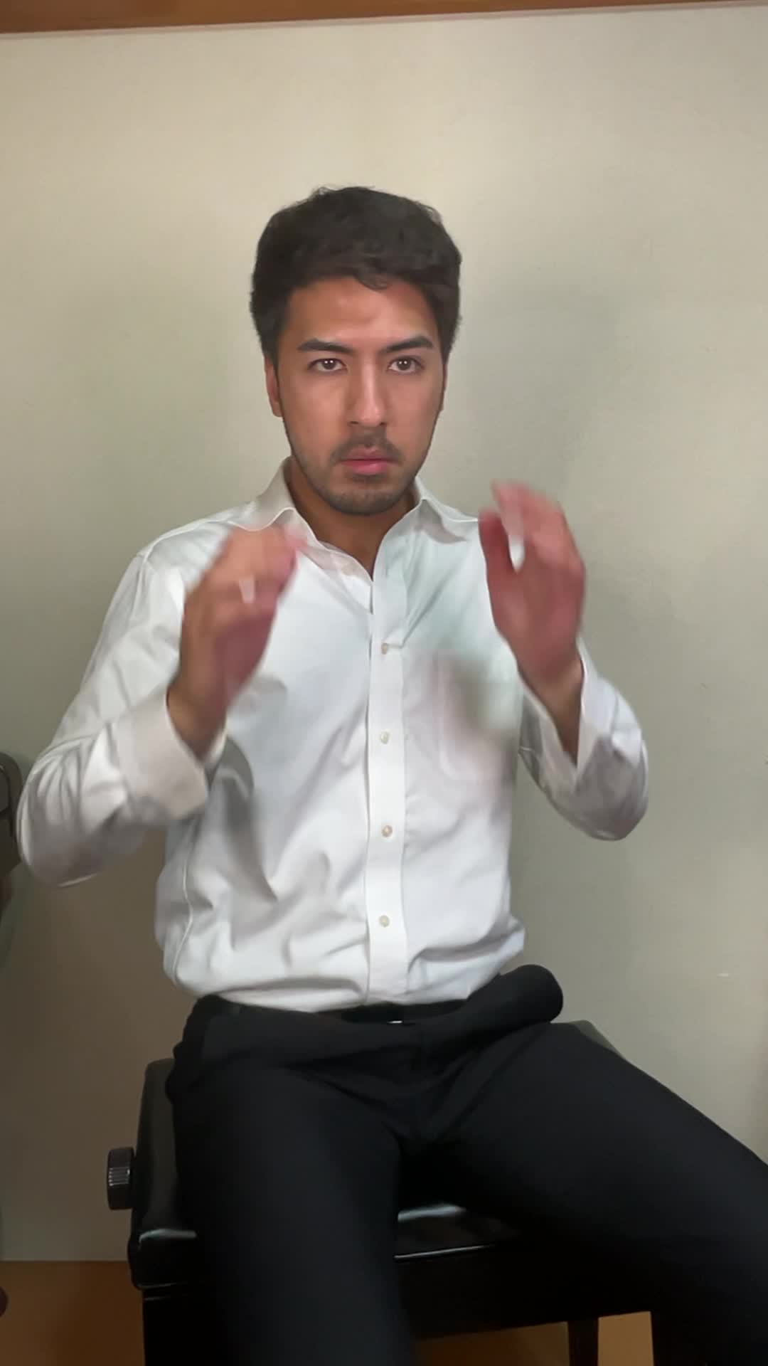 椅子に座り、手でこめかみを押さえながら「最近ずっと頭が重い」と困った表情