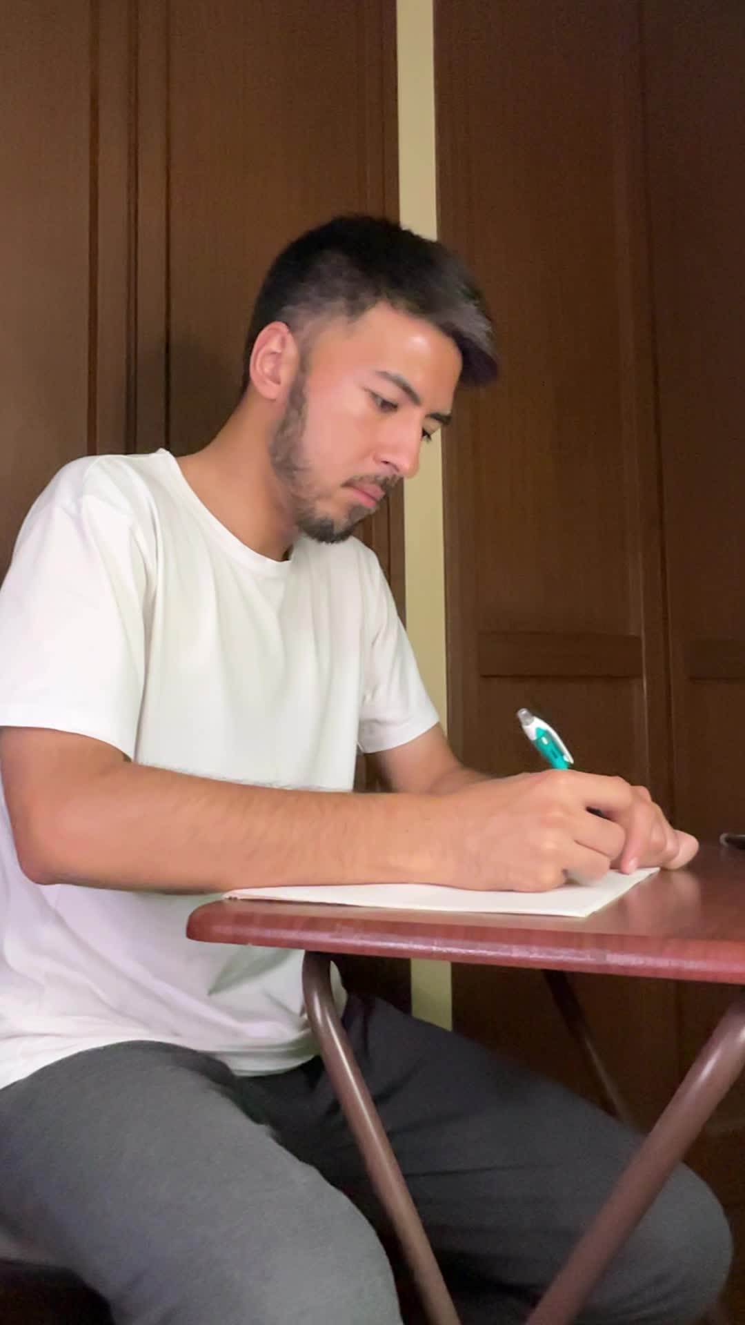 テーブルでノートに書きながら考える真剣な姿