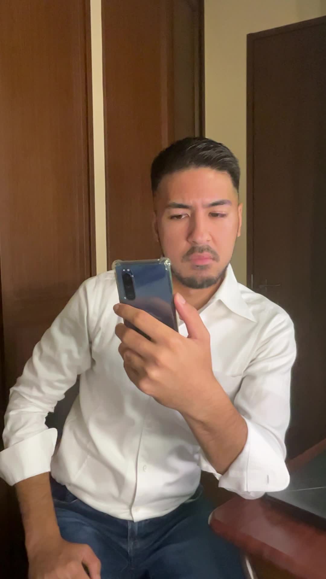 スマホを見て首をかしげ、「ちょっと怪しい？」と眉を上げる動作