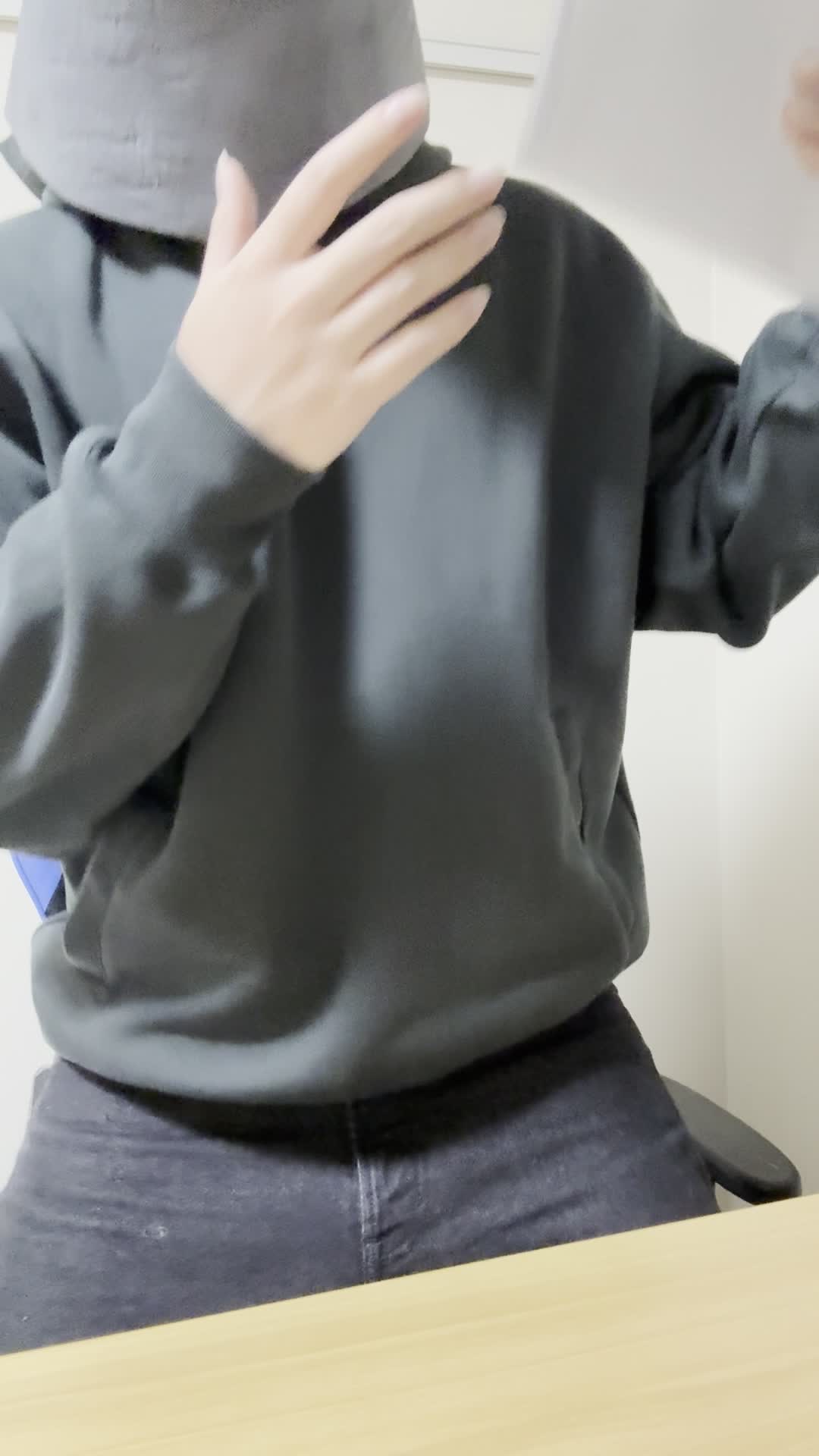 椅子に深く腰掛け、「これが私に必要な保険かも」とパンフレットを確認する動作