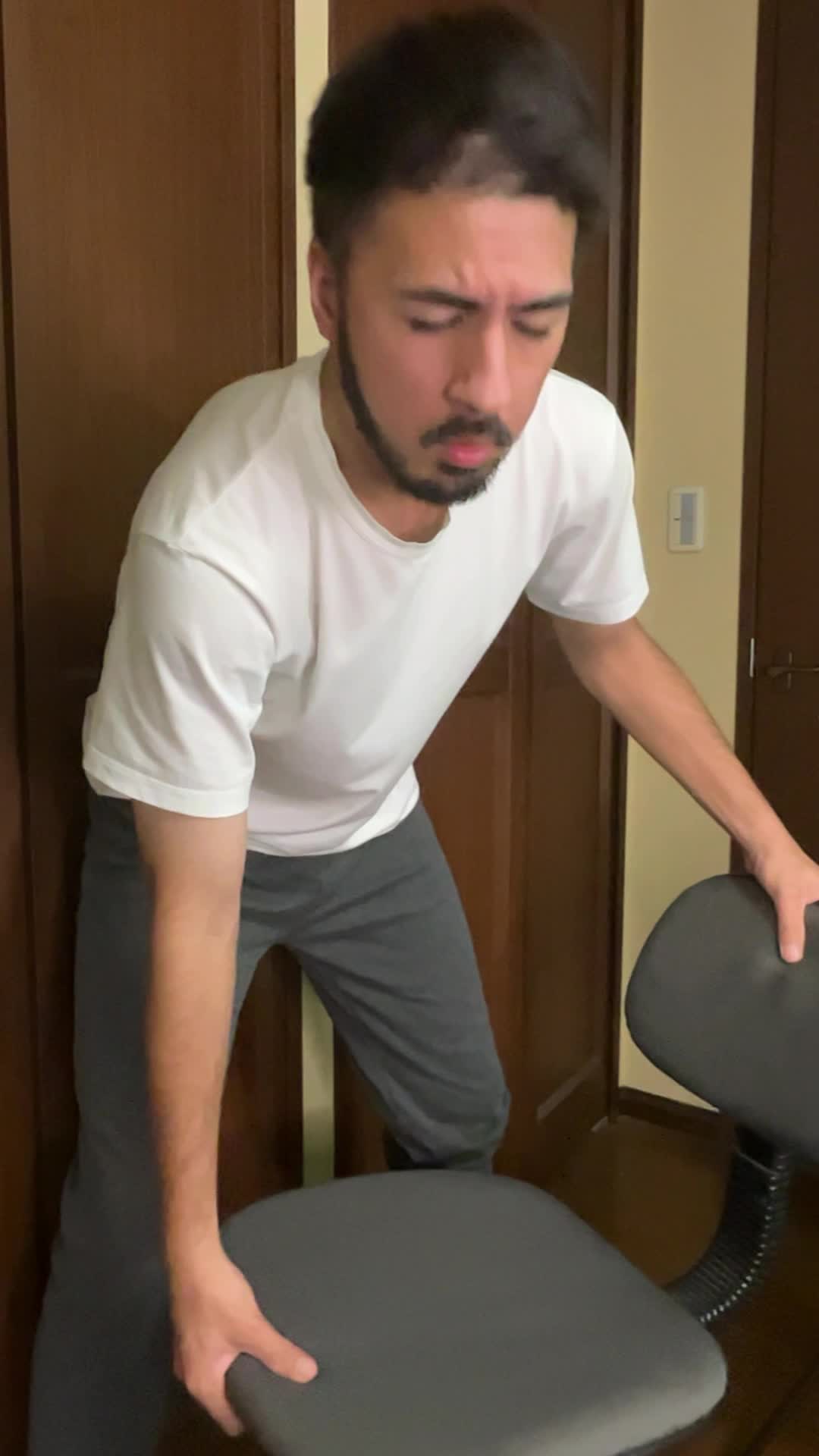 椅子を持ち上げようとして「思ったより重い…！」と驚く表情