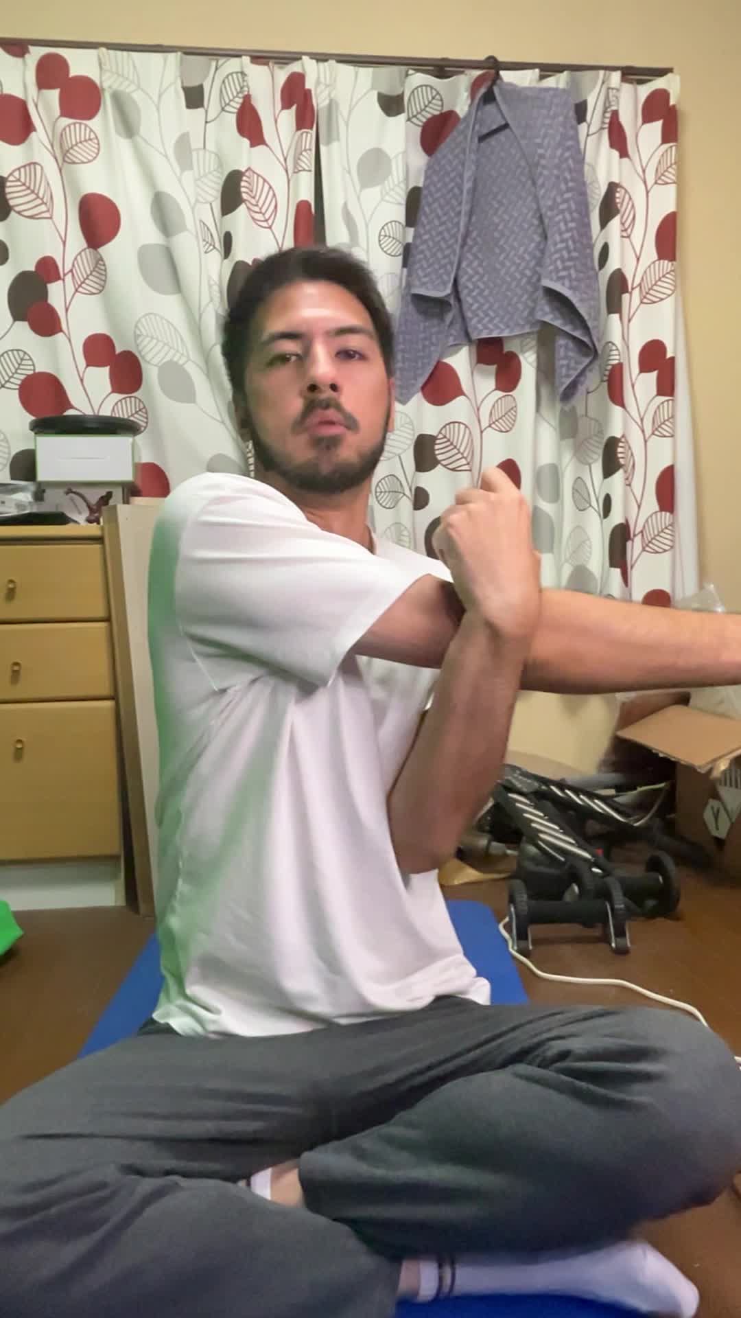 ヨガマットの上でストレッチをしながら「これなら続けられるかも」と笑う表情
