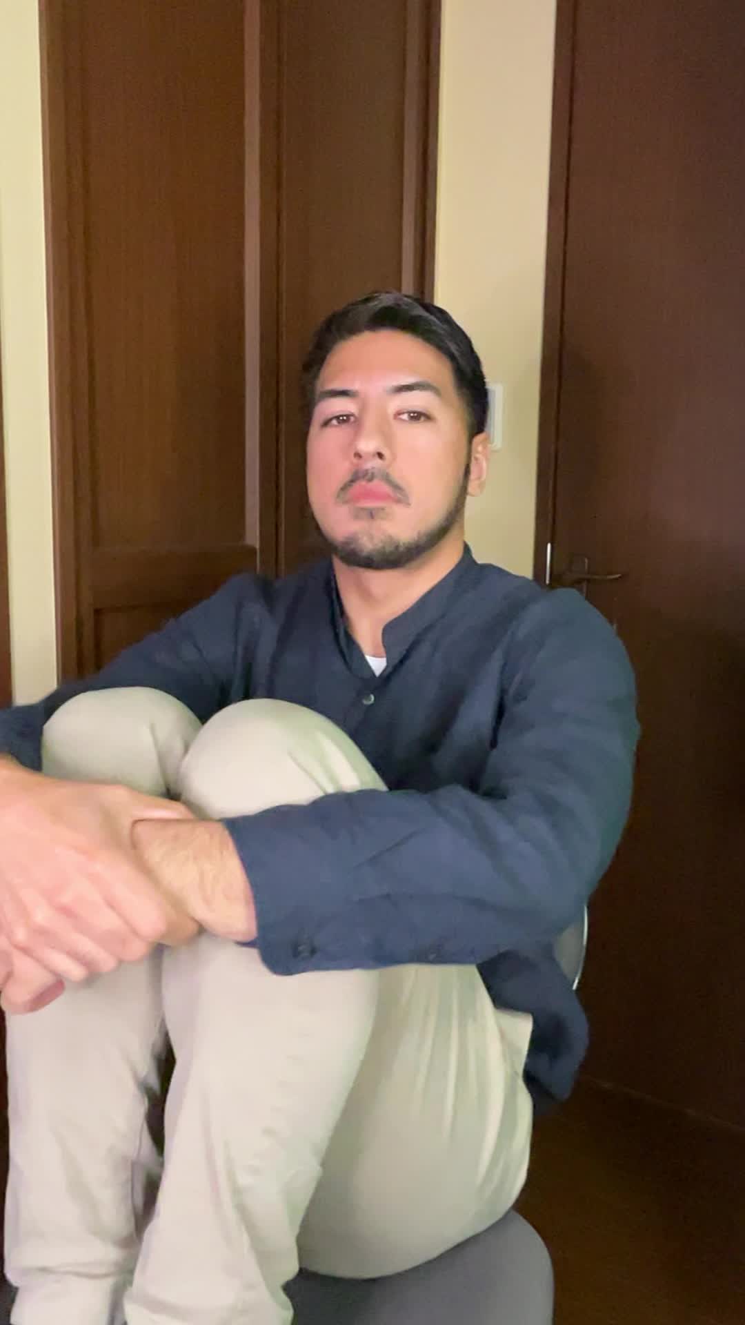 椅子に座り、「やっぱり笑顔が大事だよね」と頷く動作