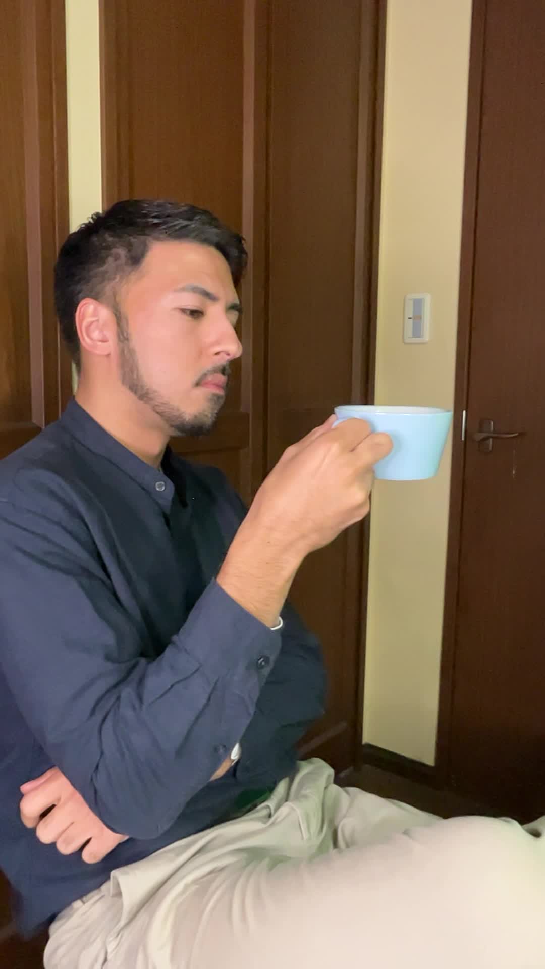 カップを持ち、「コーヒーが歯に悪いって本当かな？」と考える動作