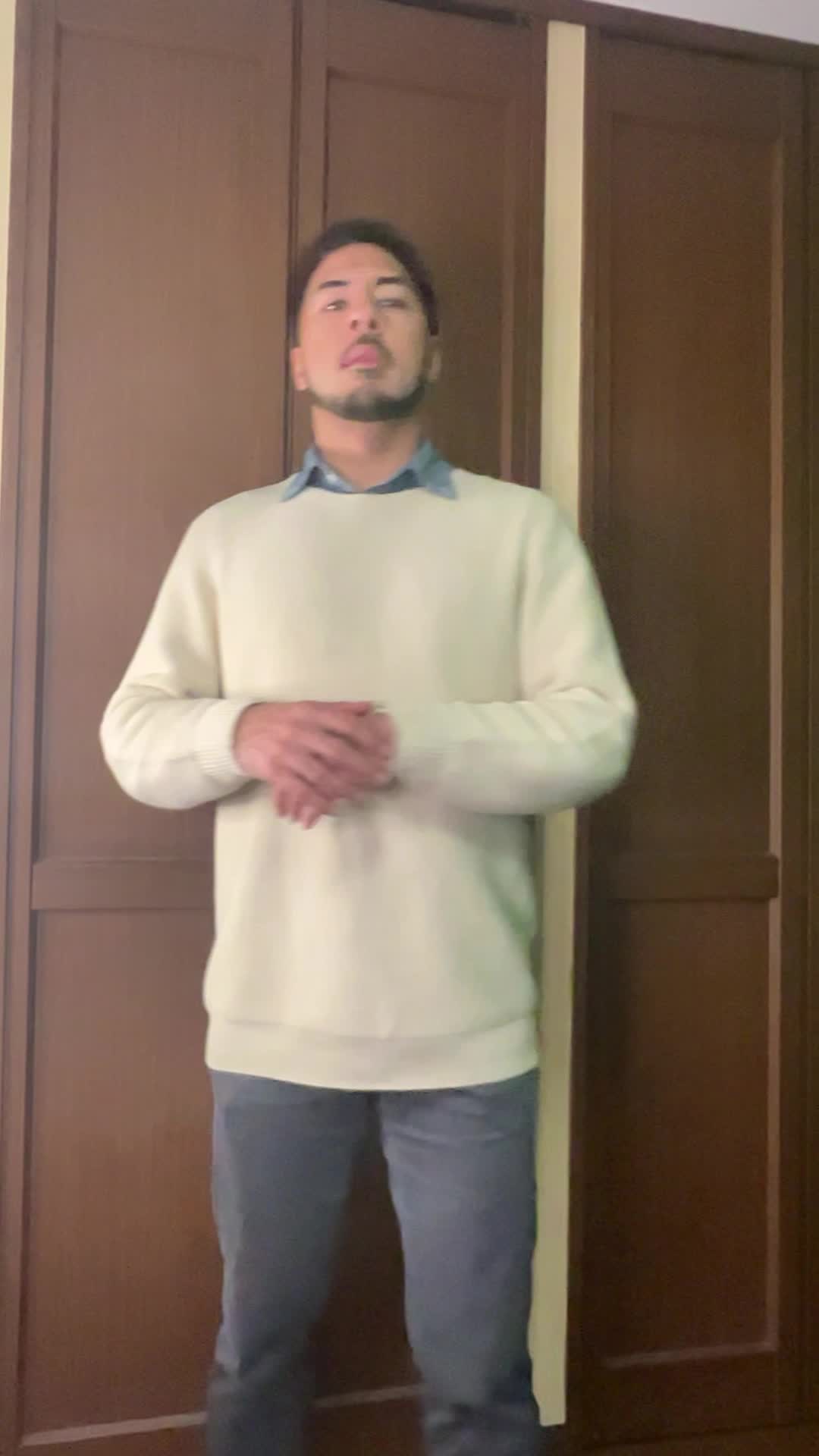 リビングで立ったまま軽く体をひねるストレッチをしている