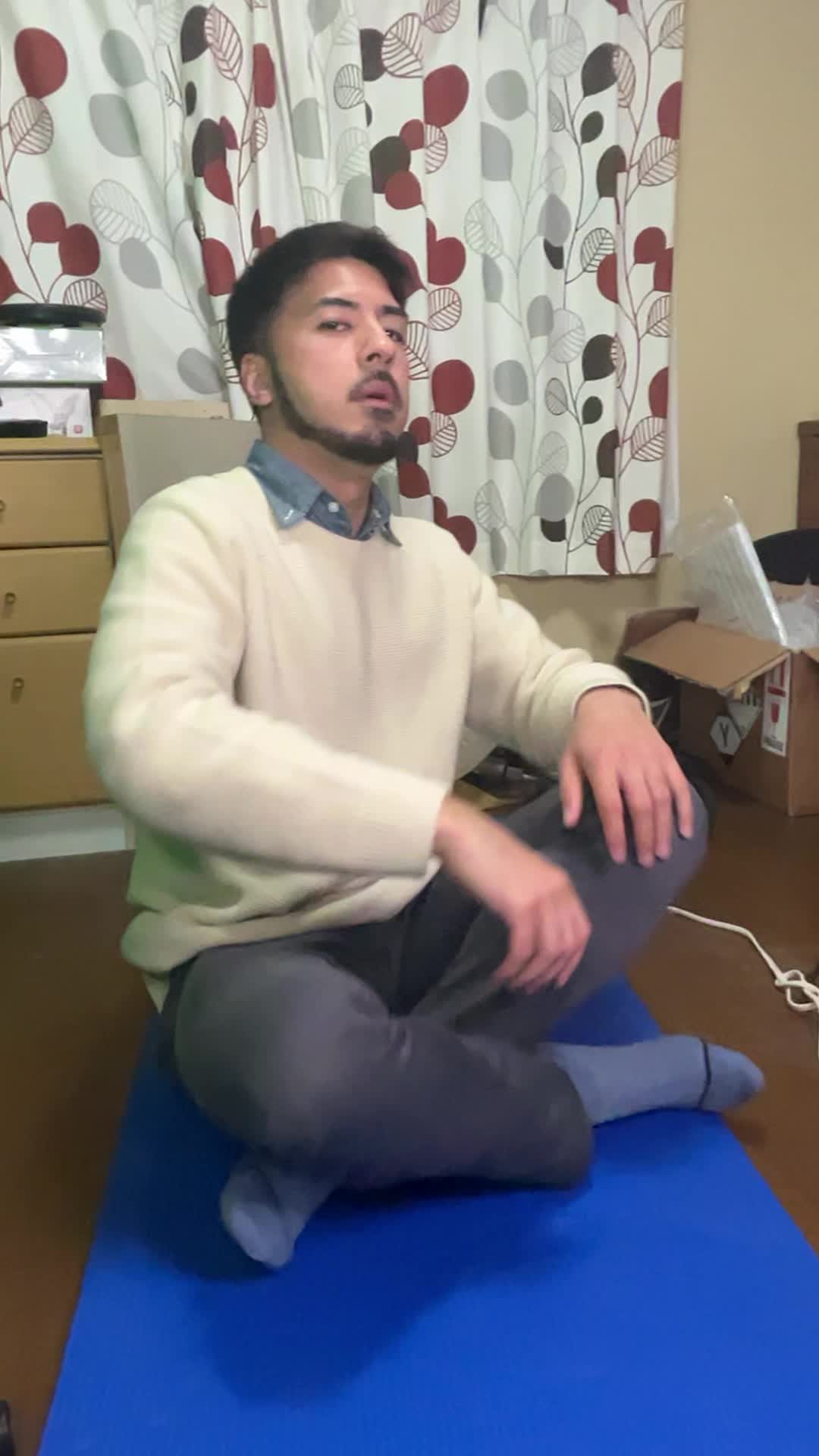 床に座り込み、軽く腕を回しながら肩をほぐしている様子