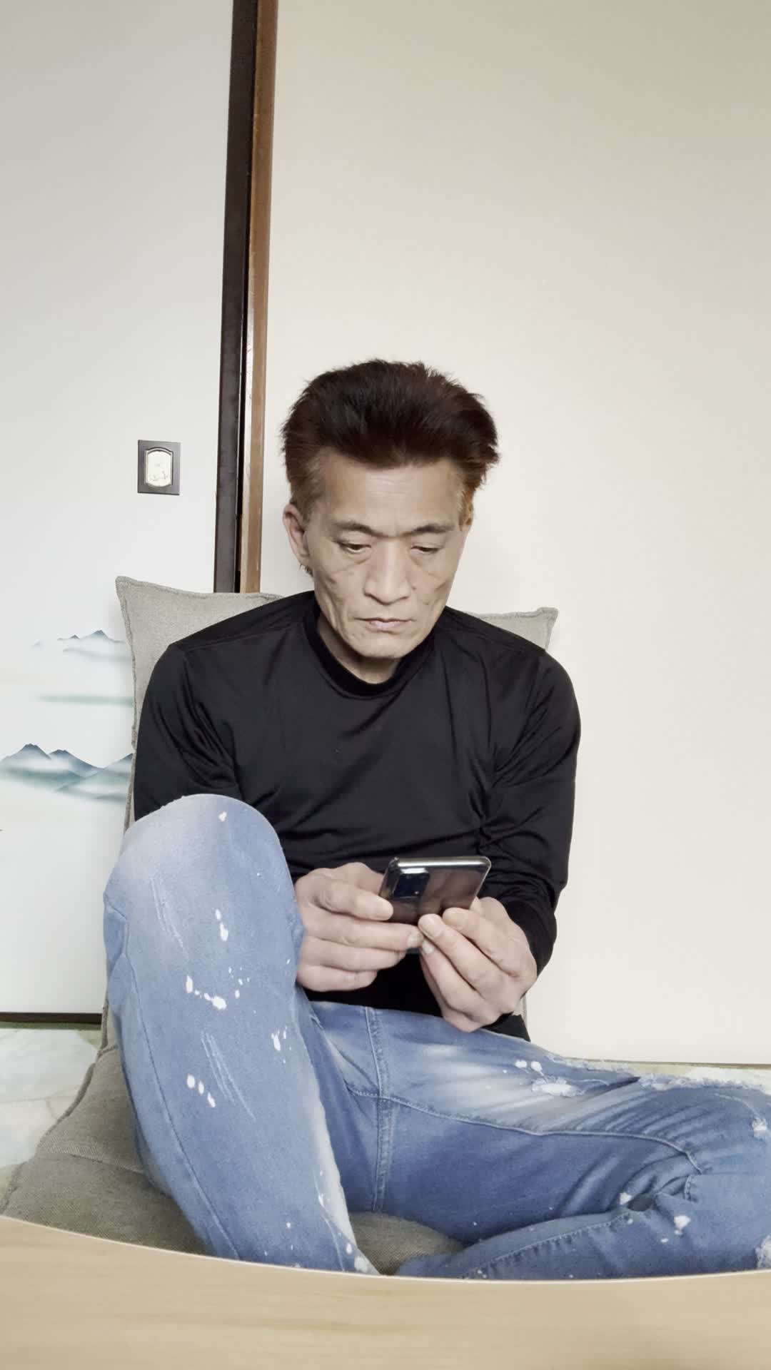ソファでスマホを眺めながら、「健康ドリンクの口コミを見て少し希望を感じる」表情
