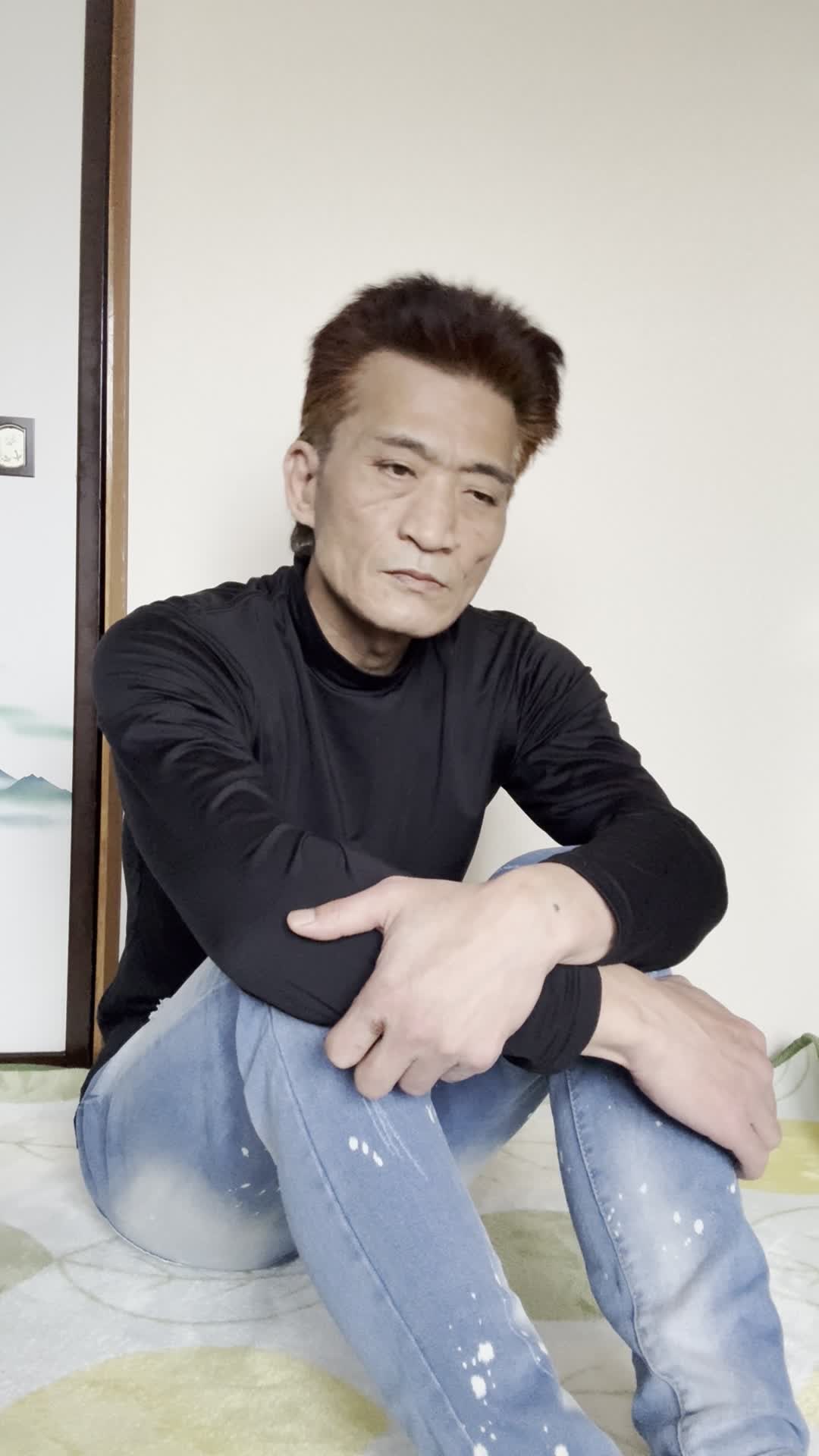 床に座り込み、「最近体が重くて動きが鈍い」と両手を膝に置いて考え込む姿