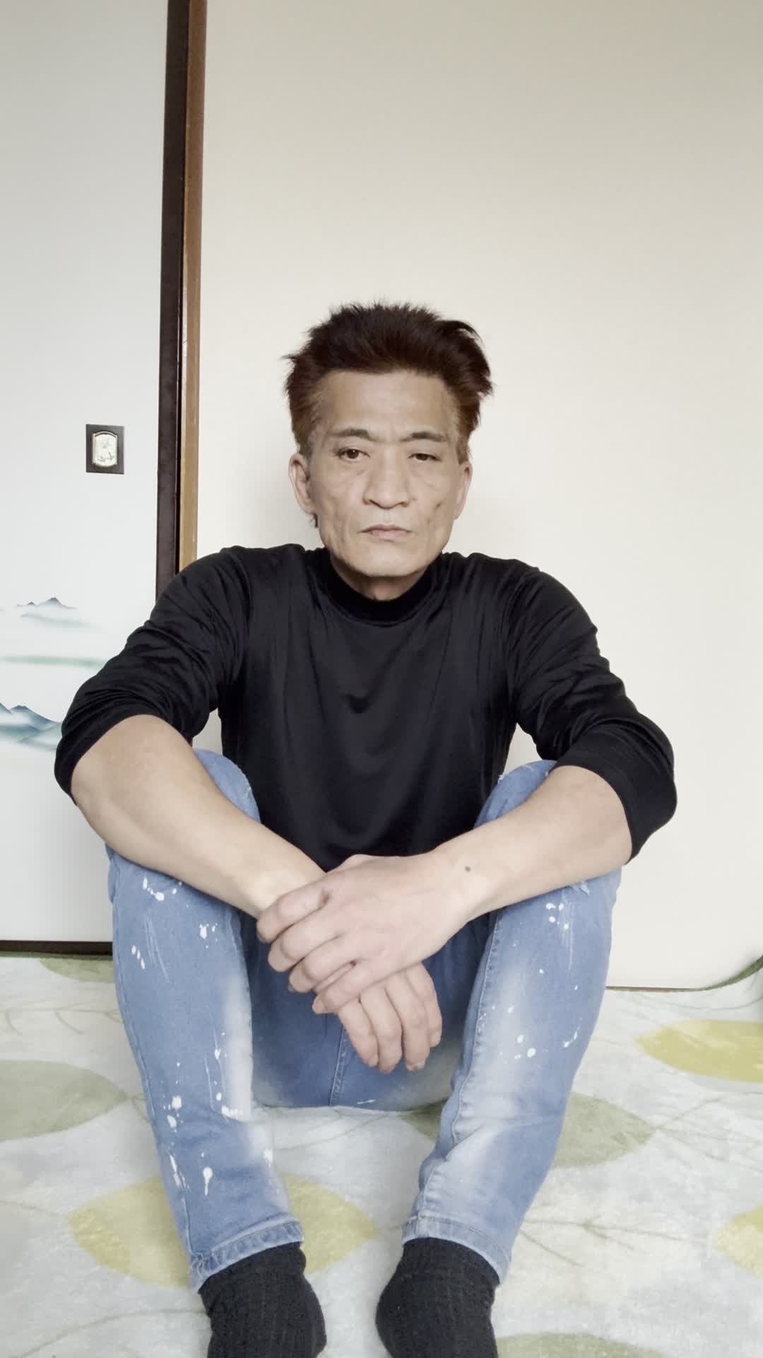 床で両手を膝に置き、「健康ドリンクで元気を取り戻したい」と決意を固める姿